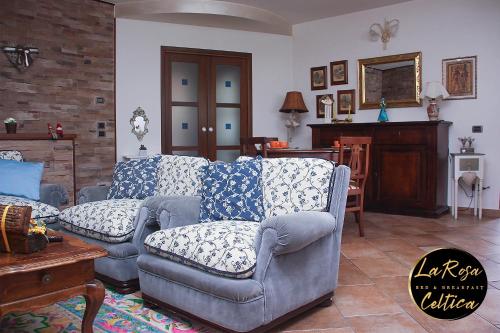 a living room with two couches and a table at B&B La Rosa Celtica in Capo di Ponte