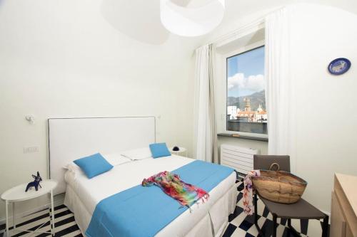アトラーニにあるLe Tre Sirene Luxury Houseの白いベッドルーム(ベッド1台、窓付)