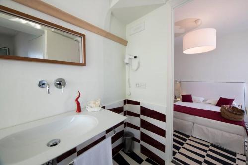 アトラーニにあるLe Tre Sirene Luxury Houseのバスルーム(バスタブ、シンク、ベッド付)