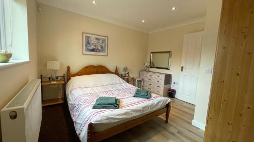 a bedroom with a bed with two towels on it at Swallows Retreat in Fordingbridge