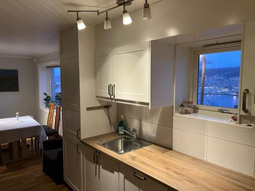 a kitchen with a sink and a window at Panorama Apartment Damsgård in Bergen