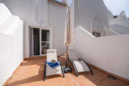 a room with two chairs and an umbrella at Casa Hibiscus Marbella in Marbella