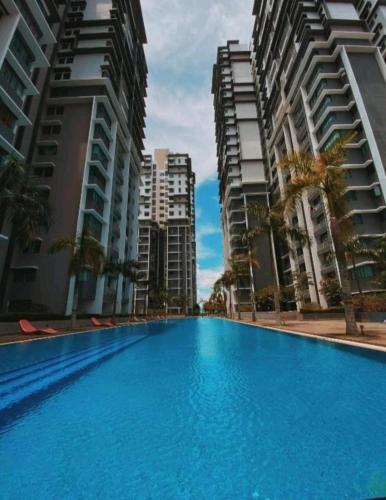 a swimming pool in the middle of two tall buildings at Damai Homestay Almyra in Kajang