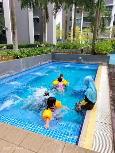 three children playing in a swimming pool at Damai Homestay Almyra in Kajang