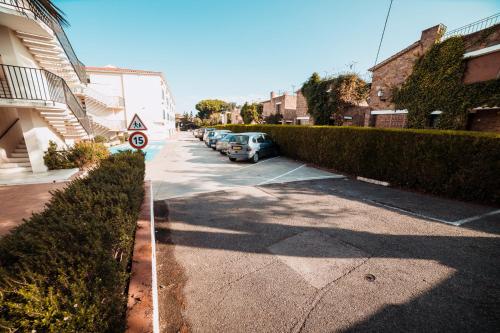 a street with cars parked in a parking lot at Apartament per parelles reformat amb piscina in Calella de Palafrugell