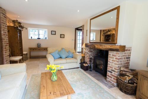 ein Wohnzimmer mit einem Sofa und einem Kamin in der Unterkunft The Old Stables, Derrydown Farm in Andover