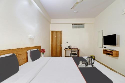 Cette chambre comprend un lit et une télévision. dans l'établissement Flagship Sri Sai Comforts, à Bangalore