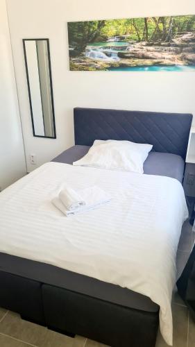 a large bed with a blue headboard with a towel on it at Dreams Beckum in Beckum