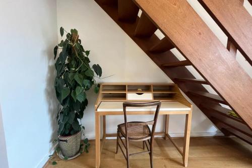 a wooden desk with a chair and a plant at Vibrant & Homely 2BD Flat - Angel in London