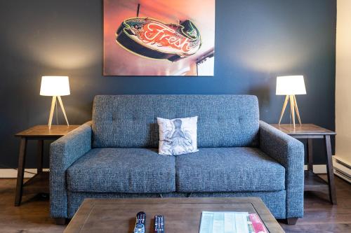a blue couch in a living room with two lamps at Kasa The Oxford Apartments Seattle in Seattle