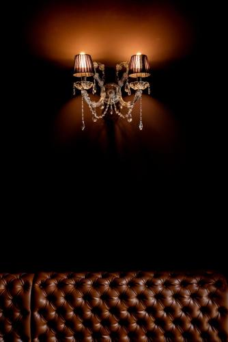 a chandelier hanging from a ceiling next to a couch at La Licorne Hotel & Spa Troyes - MGallery Collection in Troyes