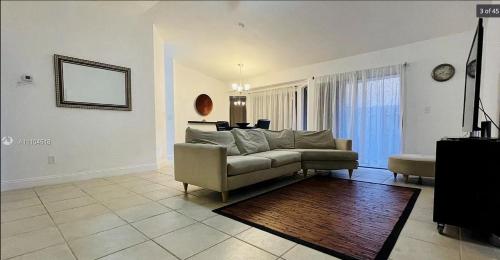 sala de estar con sofá y espejo en Luxury Private RoomBathWasher DryerWiFiMiami, en Miami