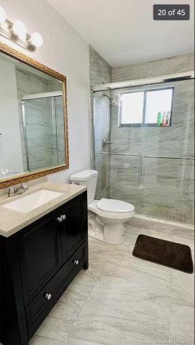 y baño con aseo, lavabo y ducha. en Luxury Private RoomBathWasher DryerWiFiMiami, en Miami