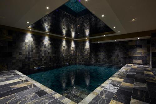 a large swimming pool in a building with a ceiling at La Licorne Hotel & Spa Troyes - MGallery Collection in Troyes