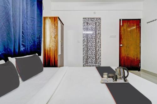 a bedroom with a bed and a door with colorful curtains at Flagship Sunshine Inn in Bangalore