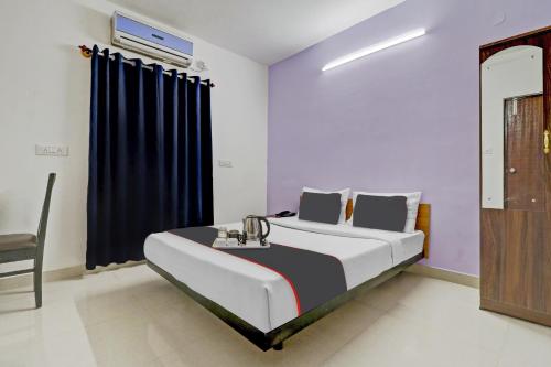 a bedroom with a bed and a blue curtain at Flagship Sunshine Inn in Bangalore