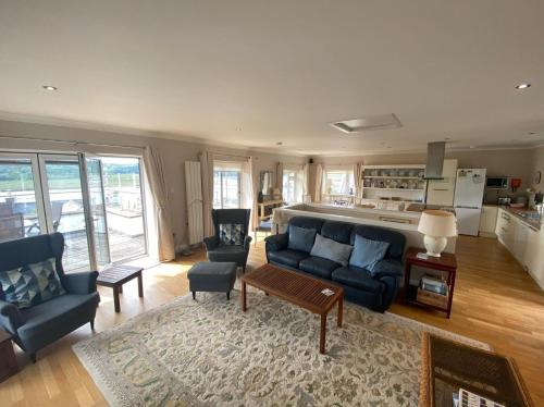 un soggiorno con divano blu e una cucina di Phoenix Cottage a Kippford