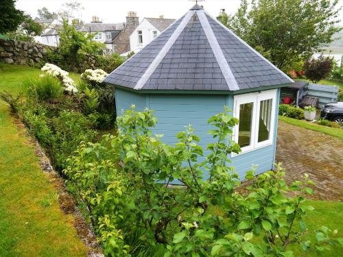 a blue dog house in a garden at Phoenix Cottage in Kippford