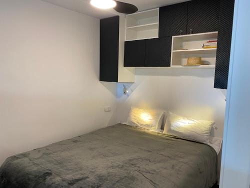 a bedroom with a bed and a black cabinet at Apartament per parelles reformat amb piscina in Calella de Palafrugell