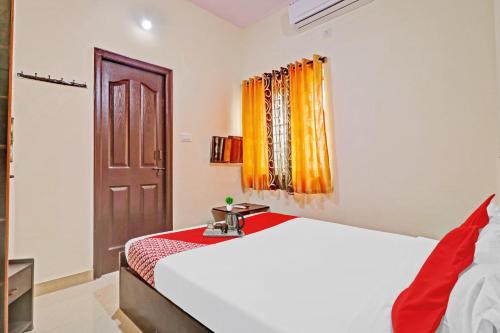 a bedroom with a white bed and a window at Super OYO Mn Residency Near Ragigudda Sri Prasanna Anjaneyaswamy Temple in Bangalore