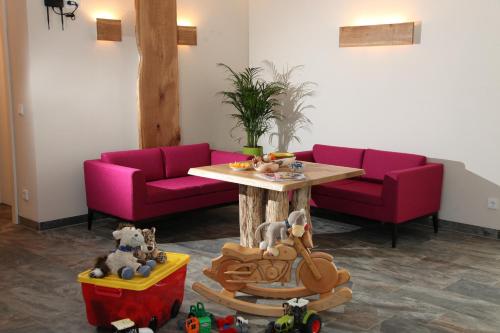a living room with pink couches and a table at K3 - Appartements in Strobl