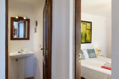 a bathroom with a sink and a bed and a mirror at Casa Los Divisos in Teguise