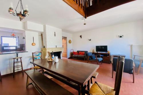 un salon avec une table en bois et un canapé dans l'établissement La Maison des Sauges - Maison de village avec Jardin à 500m de la plage, au Grau-du-Roi
