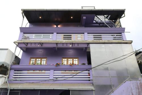 a purple building with windows and a balcony at Ammukutty's Cottage in Munnar