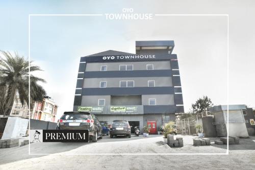 a building with cars parked in front of it at Super Townhouse Boutique Hotel 242 Sarjapur Road in Bangalore