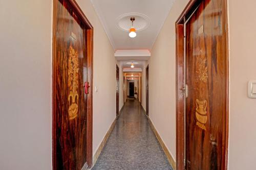 a hallway with two wooden doors and a hallway with a hallwayngth at OYO Royal Grand Residency Near Lalbagh Botanical Garden in Bangalore