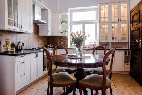 kuchnia z drewnianym stołem i krzesłami w kuchni w obiekcie HALBY Luxury Rooms Chmelna 73B w Warszawie