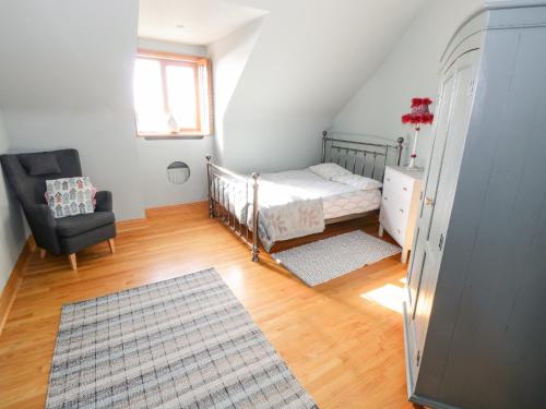 - une petite chambre avec un lit et une chaise dans l'établissement Baile Na Cille, à Knock