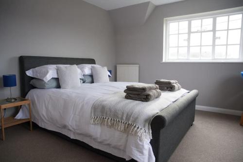 a bedroom with a large bed with towels on it at Garden House in Cirencester