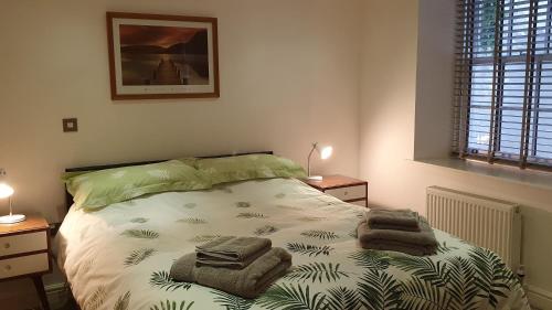 ein Schlafzimmer mit einem Bett mit Handtüchern darauf in der Unterkunft Chaucer's Retreat, Chaucer House, Keswick in Keswick
