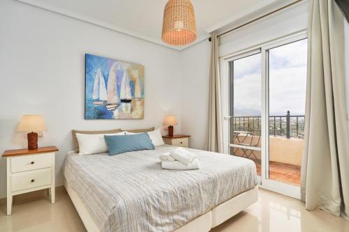 ein weißes Schlafzimmer mit einem Bett und einem Balkon in der Unterkunft Balcon Bella Vista in Nerja