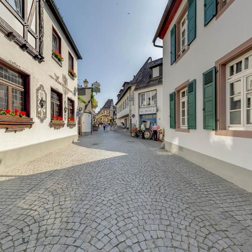 a cobblestone street in a town with buildings at Hotel Felsenkeller in Rüdesheim am Rhein