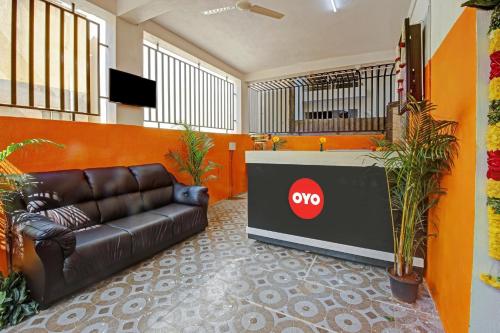 a lobby with a leather couch and a tv at Flagship Honnagiri Residency in Bangalore