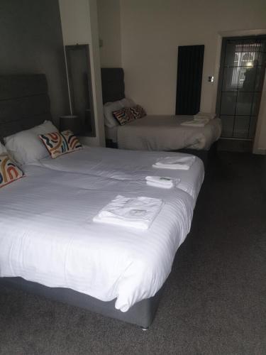 2 Betten in einem Hotelzimmer mit weißer Bettwäsche in der Unterkunft Fairway Hotel in Blackpool