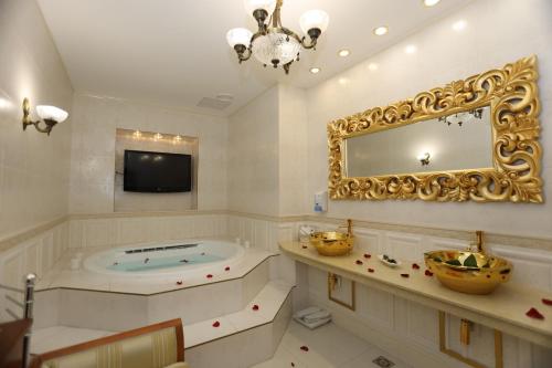 La grande salle de bains est pourvue d'une baignoire et d'un miroir. dans l'établissement Apart-hotel Integra, à Banja Luka