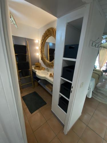 ein Badezimmer mit Waschbecken und Spiegel in der Unterkunft Studio Le paradis zen village vacances 1er étage et rdc vue mer et plage Ste Anne Guadeloupe in Sainte-Anne