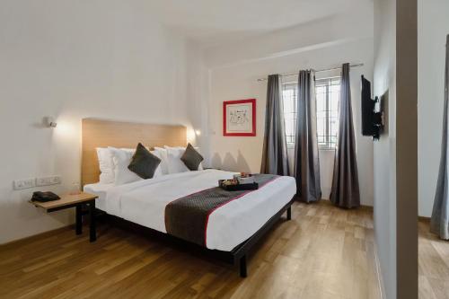 a hotel room with a large bed and a window at OYO Townhouse 093 Ramamurthy Nagar Near Baiyappanahalli Metro Station in Bangalore
