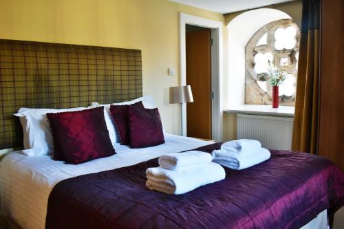 a hotel room with a bed with towels on it at The Ross 2 bedroom apartment in historic Abbey in Fort Augustus