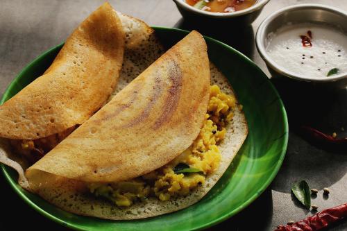 a green plate of food with two pita bread and dip at Capital O Royal Galaxy Finesse Near Phoenix Marketcity in Bengaluru