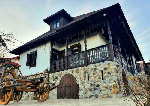 ein Gebäude mit einer Pferdekutsche davor in der Unterkunft Casa cu Cerdac in Nucşoara