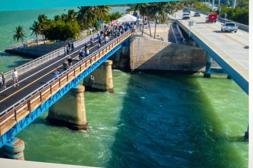 a bridge over a river with people walking on it at PARADISE AT SUNSET in Marathon