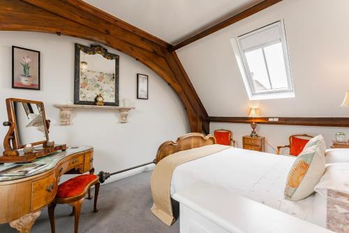 a bedroom with a bed and a desk and a mirror at Nave House - Norfolk Cottage Agency in Fakenham