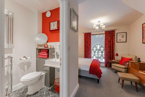 a bathroom with a bed and a toilet and a sink at Nave House - Norfolk Cottage Agency in Fakenham