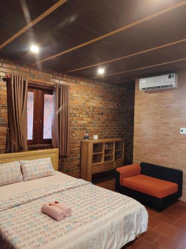 a bedroom with a large bed and a chair at Mộc Villas in Phuoc Buu