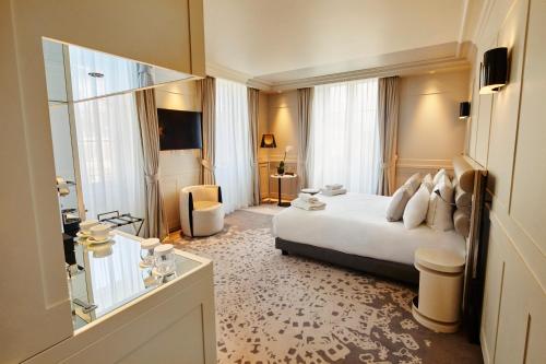 La Licorne Hotel & Spa Troyes MGallery في تروي: غرفه فندقيه بسرير ونافذه