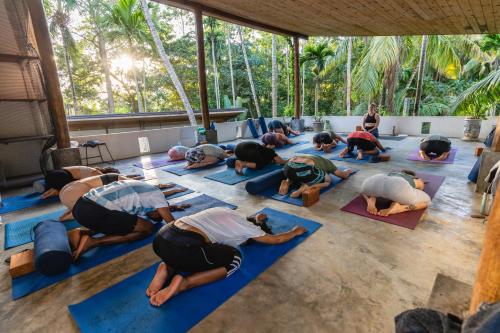 un grupo de personas haciendo yoga en una habitación en Salt House en Hiriketiya